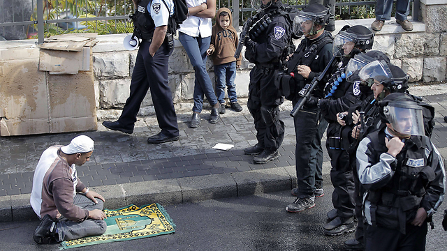 Israeli security forces in Jerusalem's Old City face a praying Palestinian (Photo: AFP)