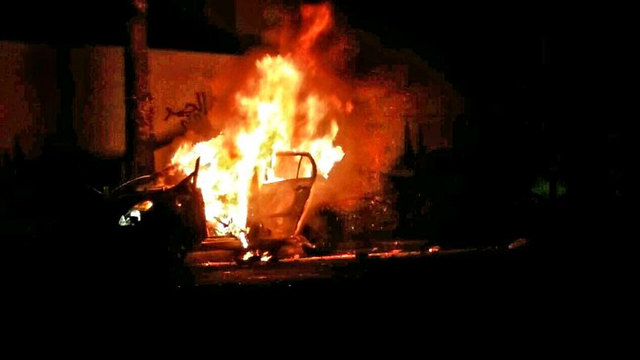 Car in flames following the aborted lynching. 