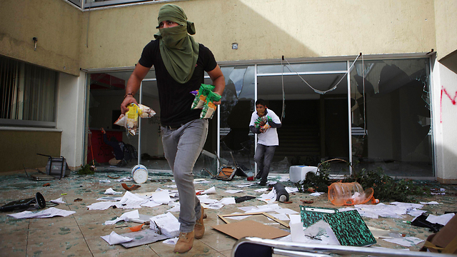 רעולי פנים גרמו נזק ובזזו את משרדי מפלגת השלטון במורליה, בירת מדינת מיצ'ואקאן (צילום: רויטרס) (צילום: רויטרס)