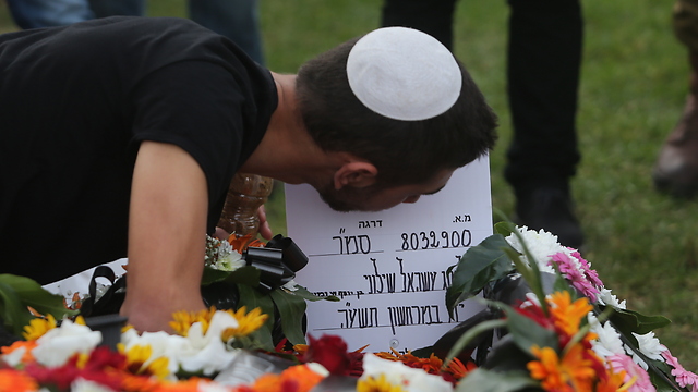 Almog's twin brother Sahar kisses the grave (Photo: Alex Kolomoisky)