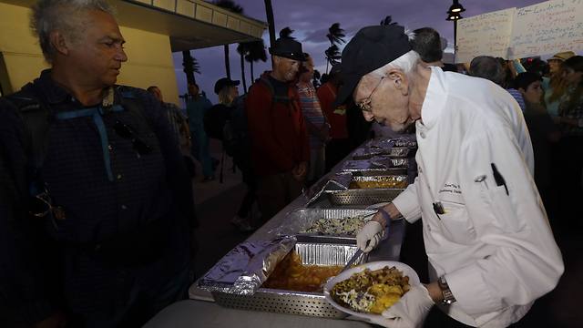 קשיש בן 90 מחלק אוכל לנזקקים בפלורידה, ארה"ב (צילום: AP) (צילום: AP)
