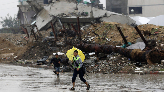 A child walks in Gaza - with an umbrella and sandals. (Photo: AFP) (Photo: AFP)