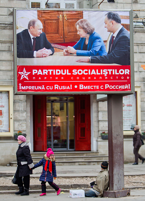 כרזת בחירות של המפלגה הסוציאליסטית שבה תמונת פוטין עם חבריה. קישינב (צילום: EPA) (צילום: EPA)