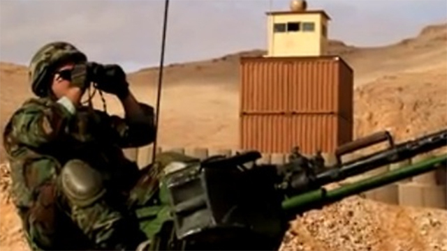 חייל לבנוני צופה על הגבול על רקע מגדלים שבנו הבריטים בראס בעלבק ()