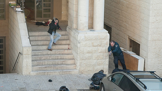 המחבל השני פורץ מבית הכנסת, חמוש באקדח וסכין קצבים (צילום: זהר רוס) (צילום: זהר רוס)