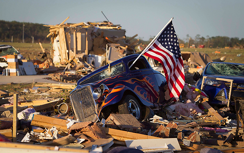 דגל ארה"ב מתנוסס מחלון מכונית בארקנסו, ארה"ב, אחרי סופת טורנדו שזרעה הרס. צילום: קרלו אלגרי (צילום: רויטרס) (צילום: רויטרס)
