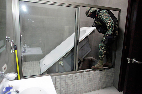 אנשי ביטחון מפנים אמבטיה שמתחתיה תעלת הברחה מביתו של ברון סמים. צילום: דניאל בסריל (צילום: רויטרס) (צילום: רויטרס)
