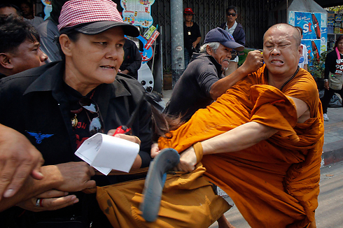 אגרוף לפרצוף. פעילי מחאה תוקפים נזיר בבנגקוק, תאילנד. צילום: צ'יוואט סובפרסום (צילום: רויטרס) (צילום: רויטרס)