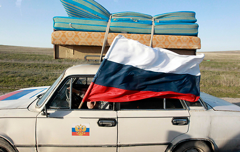 מבחינתם, הם חוזרים הביתה. רוסים עם דגל הפדרציה הרוסית בחצי האי קרים. צילום: שמיל ז'ומטוב (צילום: רויטרס) (צילום: רויטרס)