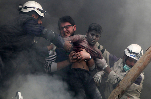 ילד מחולץ מהריסות כתוצאה מהפצצות בחלב שבסוריה (צילום: רויטרס) (צילום: רויטרס)
