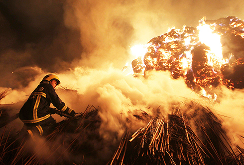 אש על הפנים. כבאי בשריפה במפעל נייר בסין (צילום: רויטרס) (צילום: רויטרס)