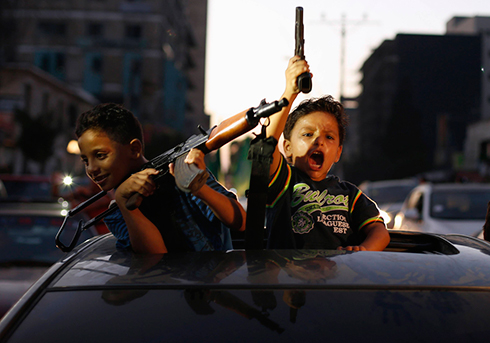 ילדים פלסטינים חוגגים עם אקדחים "ניצחון" בצוק איתן. צילום: סוחייב סאלם (צילום: רויטרס) (צילום: רויטרס)