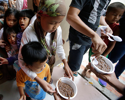 חלוקת מזון במנילה לילדים שפונו מבתיהם (צילום: AP) (צילום: AP)