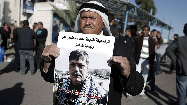 Palestinian holding sign remembering Abu Ein (Photo: AFP)