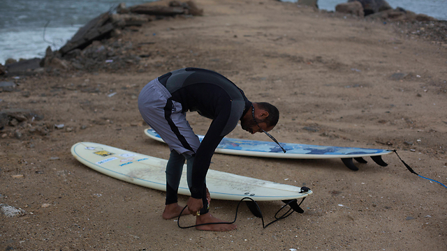 Palestinian Mohammed Abu Jayyab, 41, prepares to surf at the beach (Photo: AP) (Photo: AP)