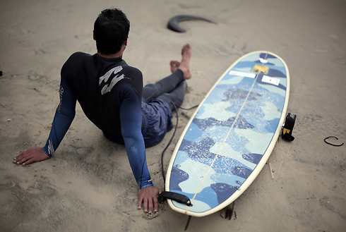 A Palestinian surfer rests next to his surf board on the beach of Gaza City (Photo: AP) (Photo: AP)