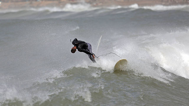 Surfer falls from his surf board after being hit by a wave (Photo: AP) (Photo: AP)
