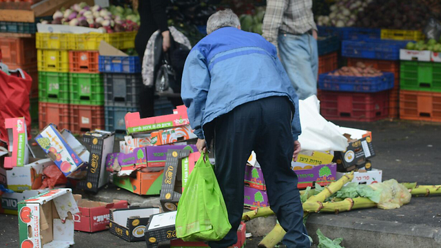 An elderly person searching for leftover food at the market in Haifa (Photo: Archive/George Ginsburg)