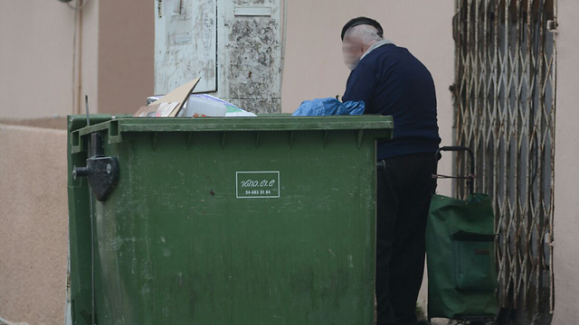 Elderly man searches for food in a garbage can in Haifa. (Photo: George Ginsburg) (Photo: Ginsburg)