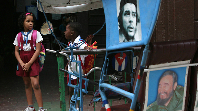 חסה תחת צלו של האח. תמונתו של פידל מתנוססת עדיין בקובה (צילום: AP) (צילום: AP)