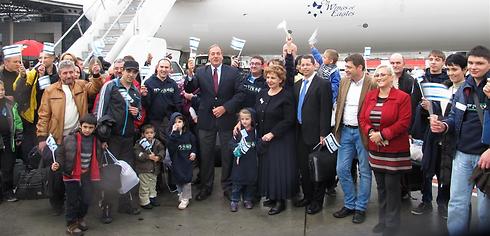 New olim from Ukraine in December 2014 with The Fellowship Founder and President Rabbi Yechiel Eckstein (center) waving Israeli flags (Photo: Olivier Fitoussi)