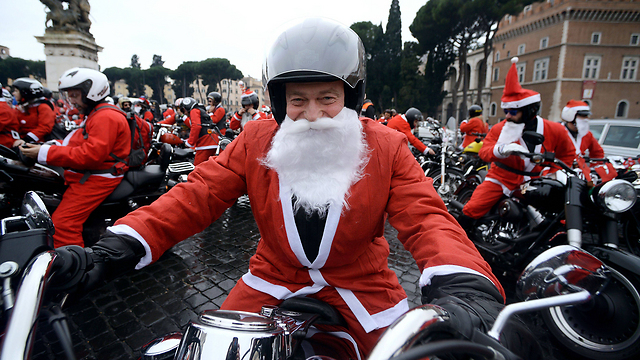 רוכבי אופנוע מחופשים לסנטה קלאוס הגיעו לסיבוב בכיכר ונציה ברומא (צילום: AFP) (צילום: AFP)