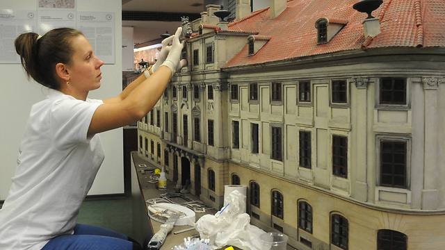 A worker finishes one of the miniature replicas of a lost building (Photo: AP Photo/Alik Keplicz)