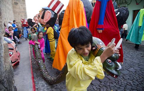 ילדים בגואטמלה נושאים נחש עשוי בד ונייר במהלך ריקוד "הענקים" (צילום: AP) (צילום: AP)