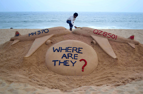 אמן החול ההודי סודרשאן פטנאיק תוהה היכן נמצאת טיסה MH370 של "מלזיה איירליינס", שנעלמה בשנה שעברה, בשבוע שבו נמצאו שברי טיסה QZ8501 של "אייר אסיה" בים ג'אווה (צילום: AFP) (צילום: AFP)