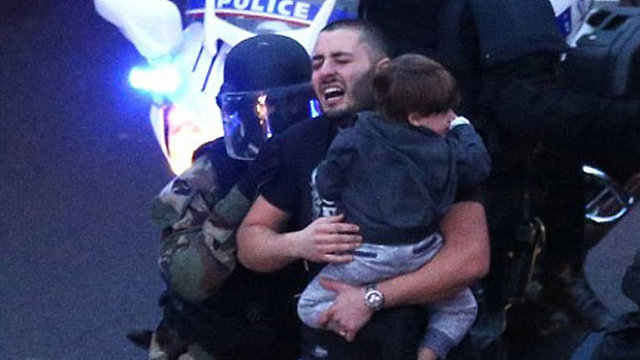 A hostage carrying a child flees the siege at the Hyper Cacher. 