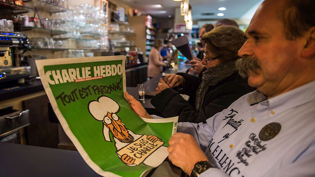 Frenchman reads new issue of Charlie Hebdo (Photo: AFP)