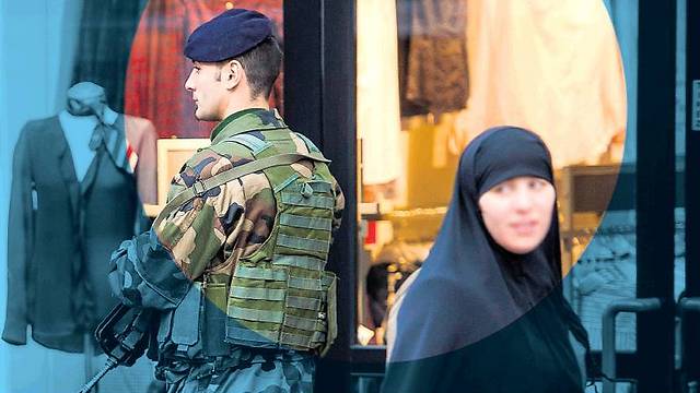 A Muslim woman stands near a soldier in Paris. The most serious problem in the Muslim world is the status of women (Photo: AFP) (Photo: AFP)