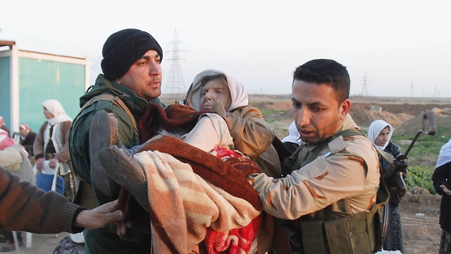 Kurdish fighters help recently released Yazidi. (Photo: Reuters)