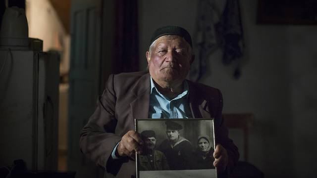 יוסוף גפרוב, בן לקהילה הטטרית שגורשה מחצי האי קרים, מחזיק בתמונת הוריו שמתו בגירוש (צילום: AP) (צילום: AP)