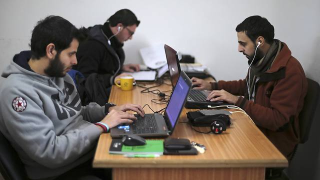Palestinian employees process data on their laptops at Unit One in Gaza City (Photo: Reuters)