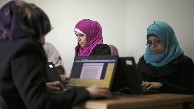 Palestinian employees process data on their laptops at Unit One in Gaza City (Photo: Reuters)