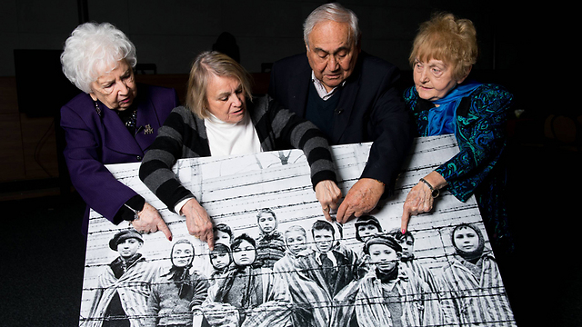 ניצולי שואה מצביעים על תמונותיהם כילדים באושוויץ (צילום: getty images) (צילום: getty images)