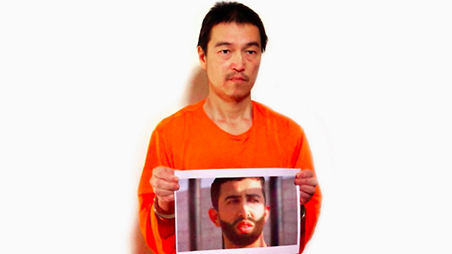Japanese hostage Kenji Goto holding picture of Jordanian pilot