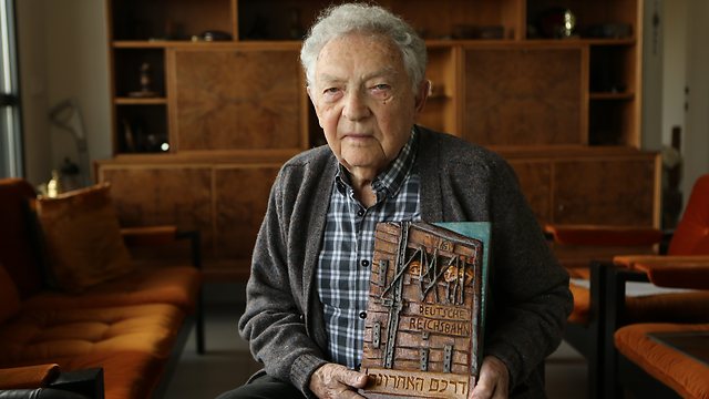 Yitzhak Arad with one of his carvings. 'Some people etch landscapes, others etch stories' (Photo: Zvika Tishler)