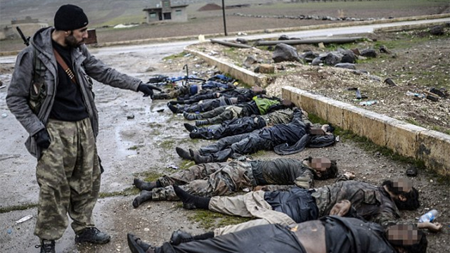 לוחם כורדי לצד גופות אנשי דאעש (צילום: AFP) (צילום: AFP)