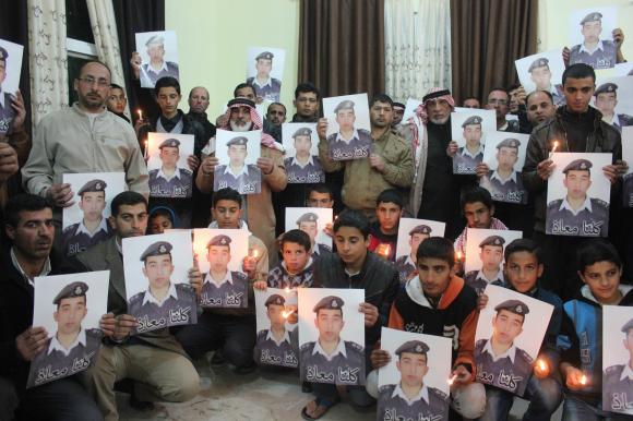 Relatives of Jordanian pilot hold his portrait as they take part in a rally in his support in Karak (Photo: Reuters) (Photo: Reuters)