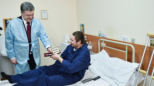 נשיא אוקראינה פורושנקו מעניק עיטור לחייל פצוע בבית חולים בעיר חרקוב (צילום: AFP PHOTO/ UKRAINIAN PRESIDENTIAL PRESS SERVICE / MYKOLA LAZARENKO) (צילום: AFP PHOTO/ UKRAINIAN PRESIDENTIAL PRESS SERVICE / MYKOLA LAZARENKO)
