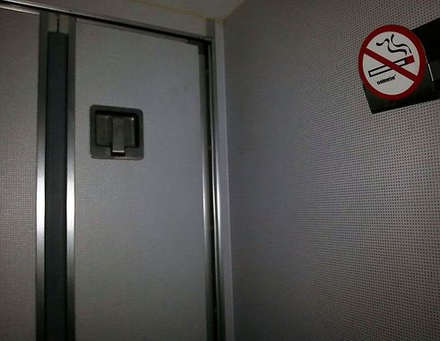 תא שירותים במטוס אל על. מימין: איסור העישון (ערן בר און)
