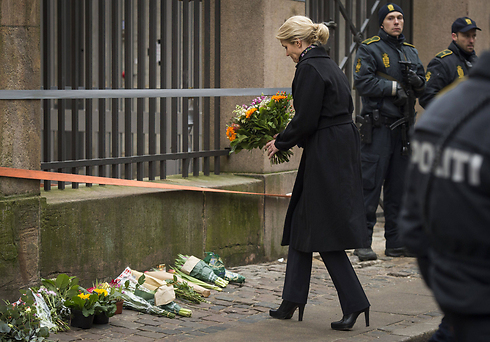 ראש ממשלת דנמרק, הלה ת'ורנינג שמידט, מניחה פרחים בבית הכנסת (צילום: AFP) (צילום: AFP)