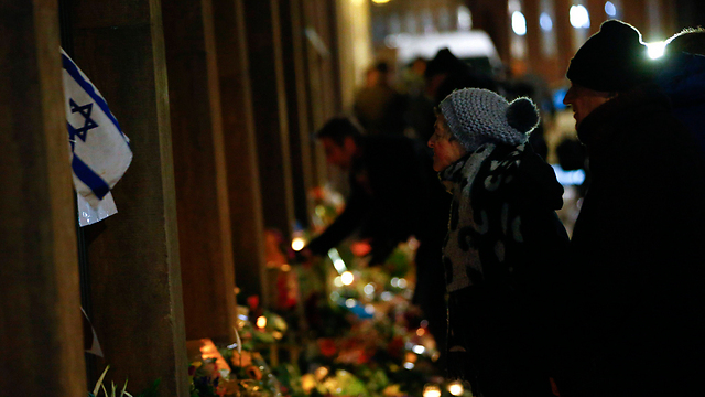 Flowers and memorial candles outside Copenhagen synagogue. 'We must not keep quiet in light of ignorance, blindness and political correctness' (Photo: MCT)