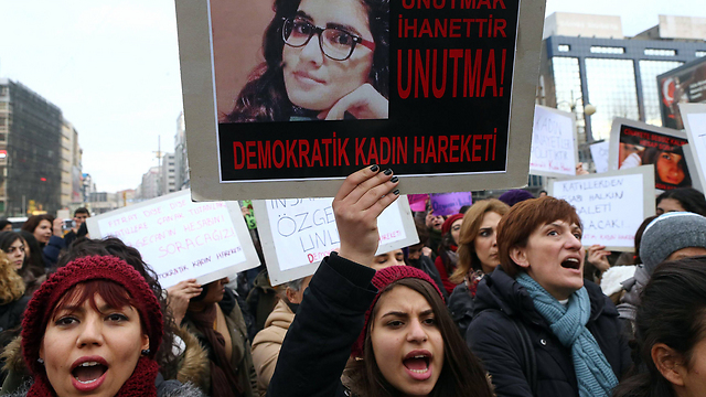 מפגינות באנקרה נגד אלימות נגד נשים עם תמונתה של הנרצחת, אוזקאן אסלאן (צילום: AFP) (צילום: AFP)
