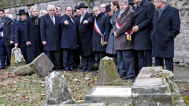 Hollande, center, with at his right, Israeli ambassador to France Yossi Gal, points to desecrated tombstones during a visit at Sarre-Union Jewish cemetery, eastern France (Photo: Associated Press) (Photo: Associated Press)