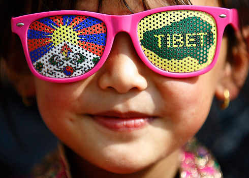 ילדה טיבטית מרכיבה משקפיים שעליהם מוטבעים דגל טיבט ומפת החבל במהלך חגיגות השנה הטיבטית החדשה בלאליטפור, נפאל  (צילום: רויטרס) (צילום: רויטרס)