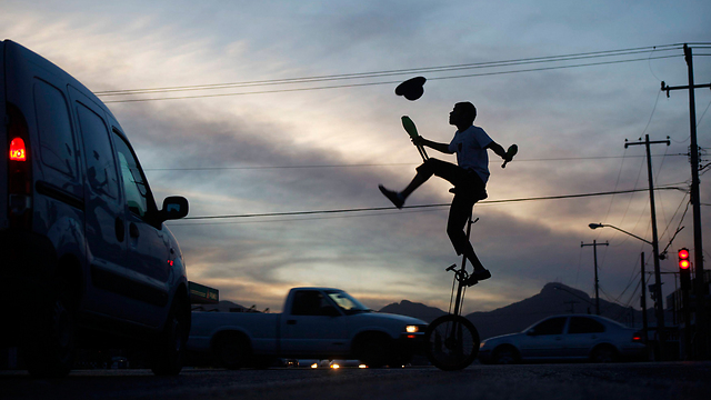 להטוטן משעשע את הנהגים בצומת סואן בעיר סיודאד חוארס במכסיקו (צילום: רויטרס) (צילום: רויטרס)