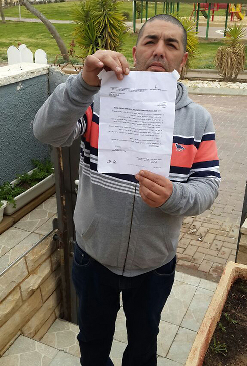Maxim Dahan, father of three, holds up his dismissal letter. 